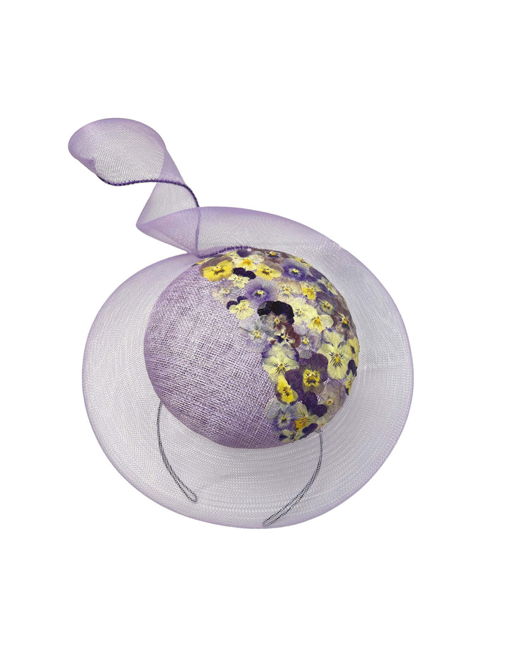 Decorative purple ball with floral pattern inside a sheer white circle on a white background