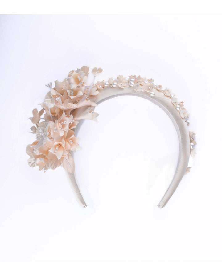 Still life picture of Beige coloured silk sateen ivory headband decorated with ivory cotton flowers an ivory beads. Made by Merve Bayindir.