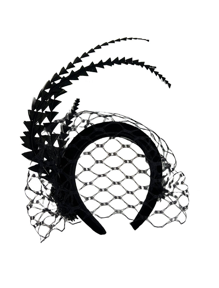 Black decorative headpiece with feathers and netting on a white background