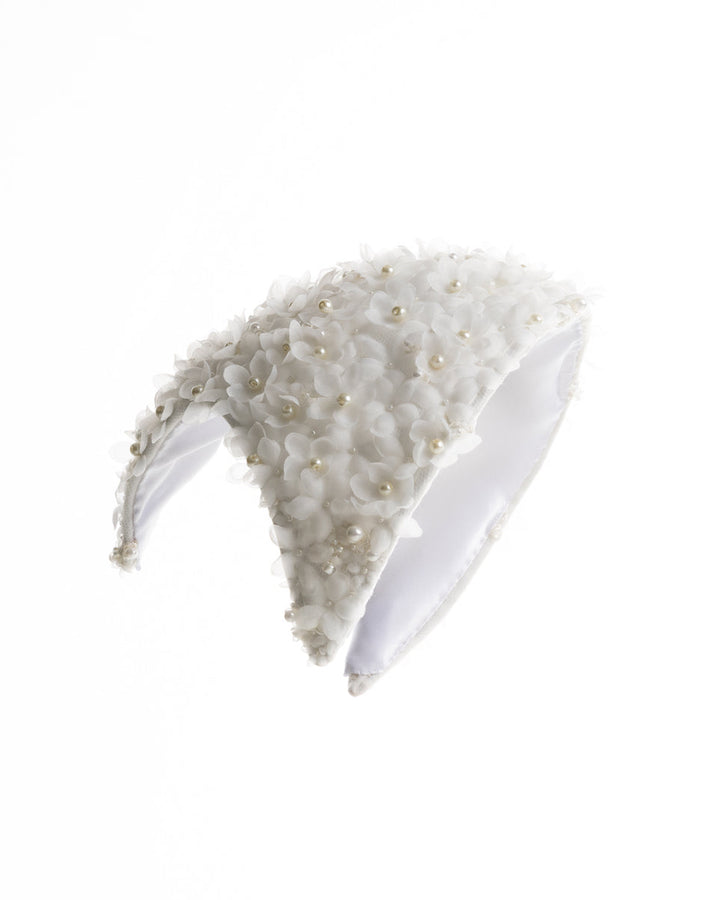A custom shaped bridal headpiece embellished with small organza flowers and pearl beads.