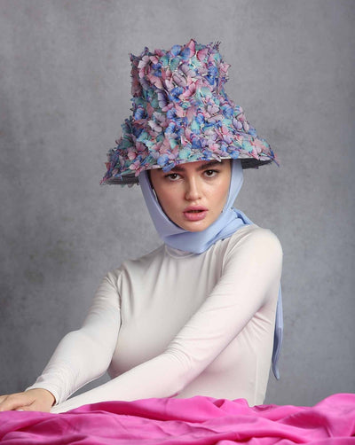 High fashion blue bucket hat tide to the head with blue slik chiffon ribbons, adorned with multi colour organza butterflies 