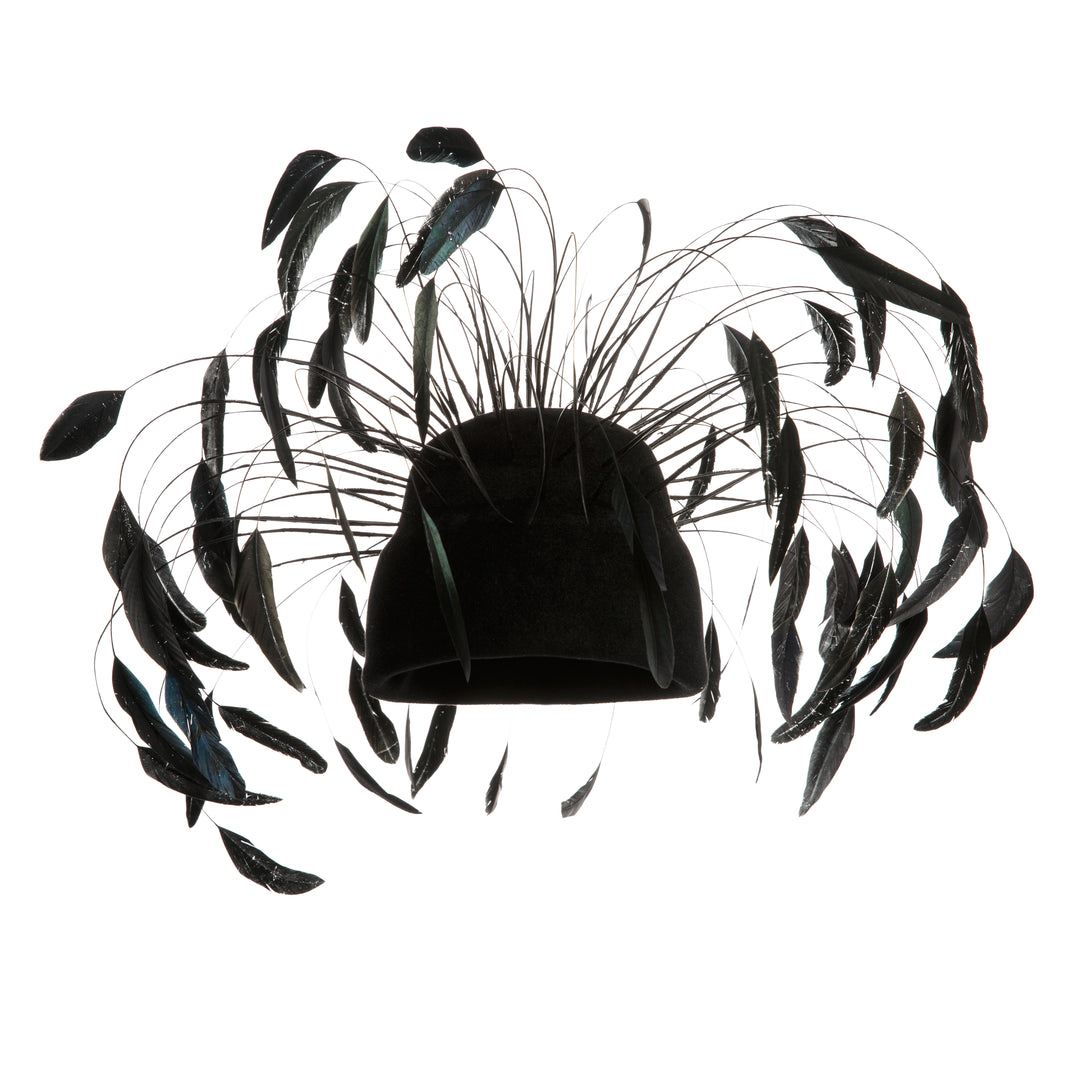 Model is showcasing Tall double pillbox felt base decorated with long Chanel style feathers surrounding the hat