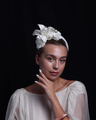 Model is wearing a sateen bridal headband decorated with custom made, white sateen irises.