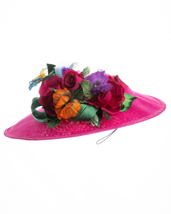 A medium sized, hot pink medium teardrop saucer decorated with a bouquet of eye-catching pink roses, multi-coloured violets and emerald leaves. Designed and made by Merve Bayindir Millinery.
