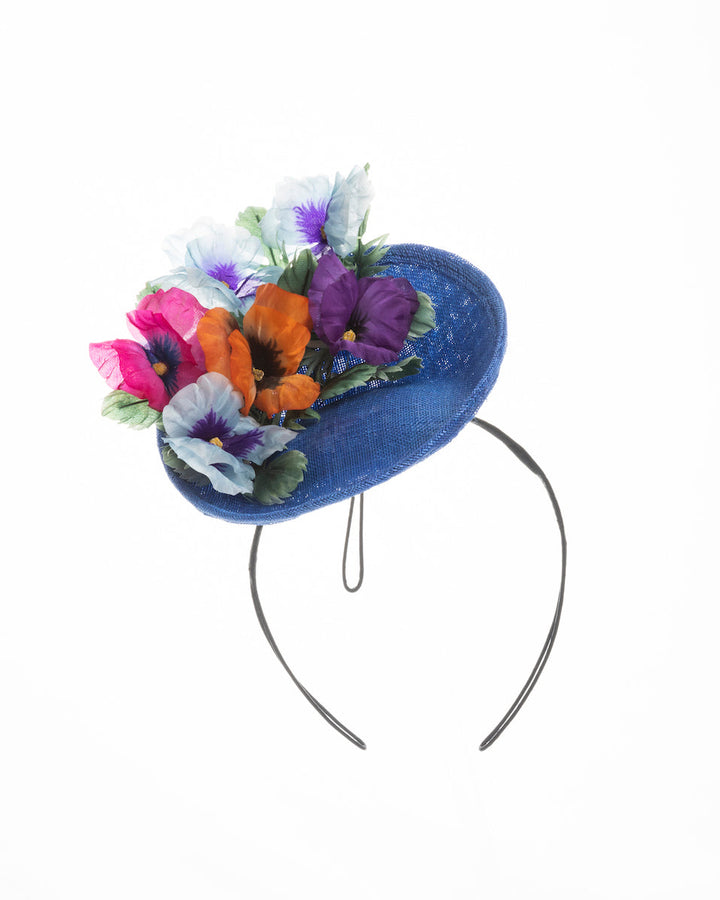 Deep blue saucer style mini fascinator, decorate with different coloured violet flowers. Designed and made by Merve Bayindir Millinery.

