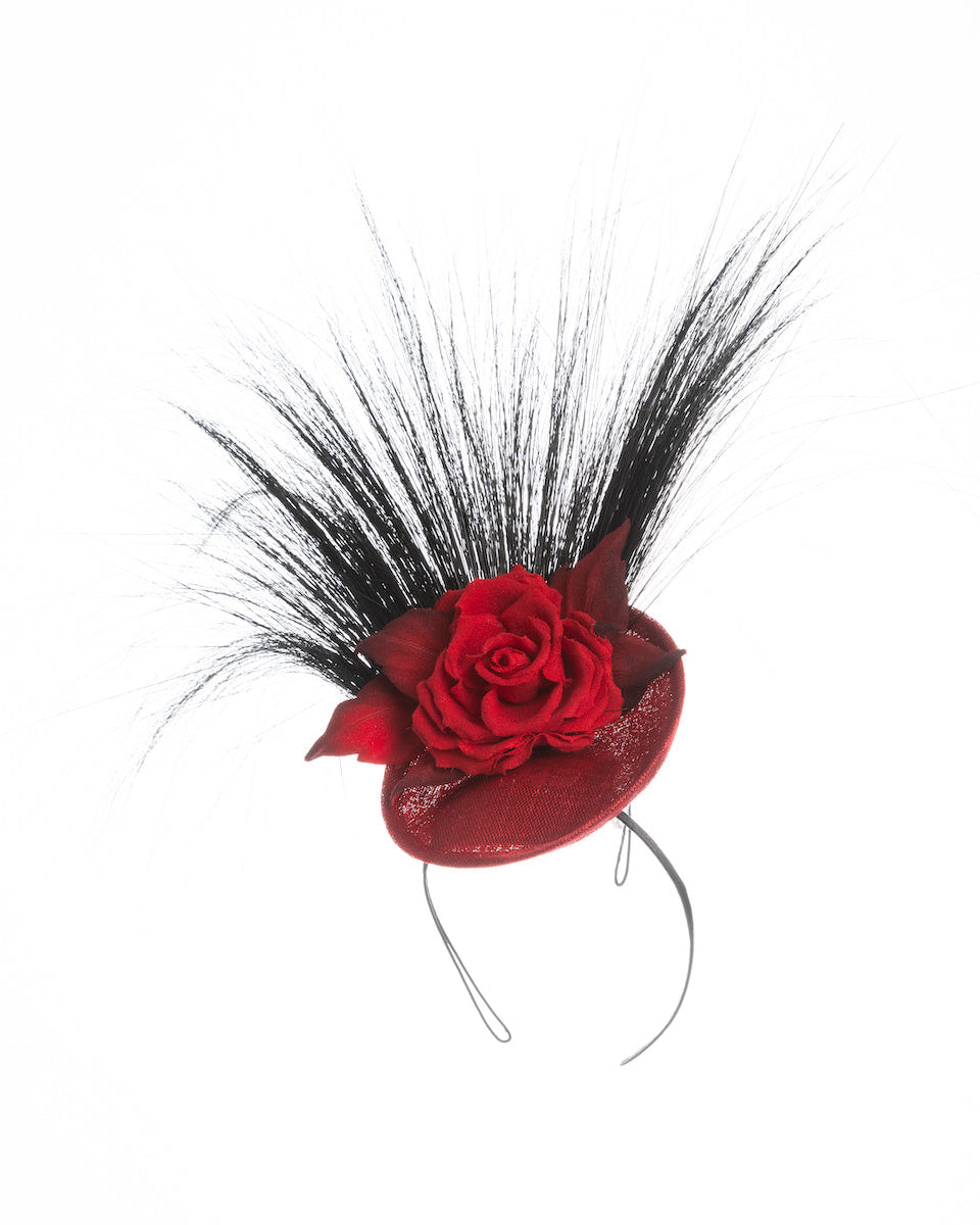 Mini red saucer fascinator, adorned with a red rose embellished with high rising black burnt peacock feathers. Designed and made by Merve Bayindir millinery.