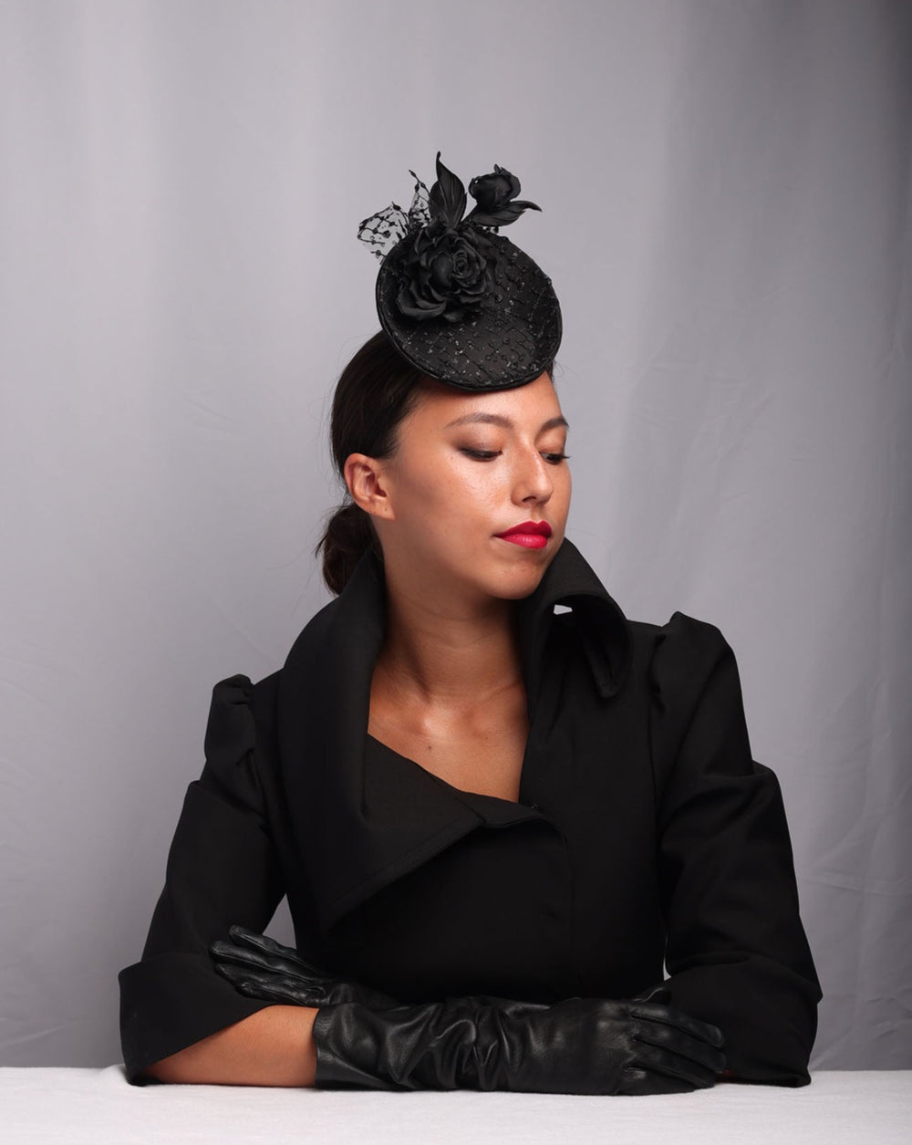 Model is showcasing Small saucer style sateen fascinator, embellished with sparkled lace tulle and sateen roses