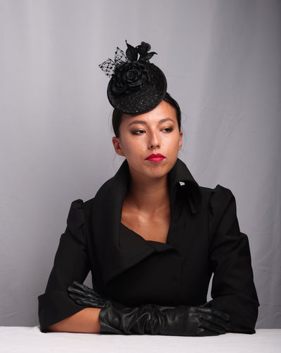 model is showcasing the front view of a Small saucer style sateen fascinator, embellished with sparkled lace tulle and sateen roses. Ideal for formal events, suitable for funurals.